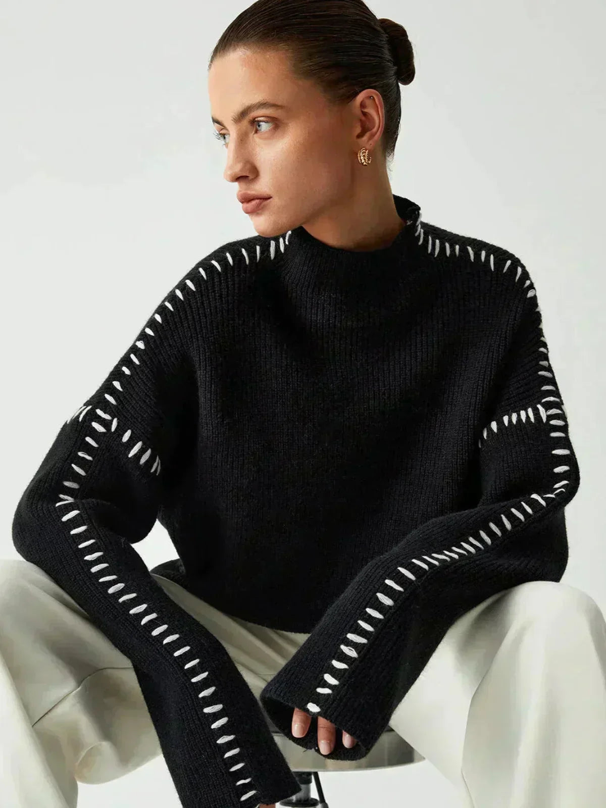 A high neck jumper worn with cream trousers